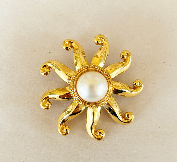 Vintage 80s signed Trifari sun brooch with large faux pearl center.