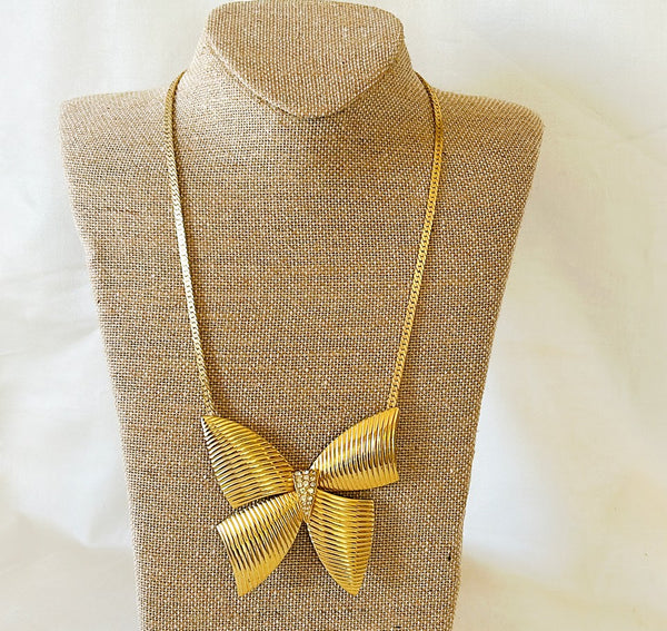 Adorable 80s gold necklace with extra large bow with rhinestone accents.