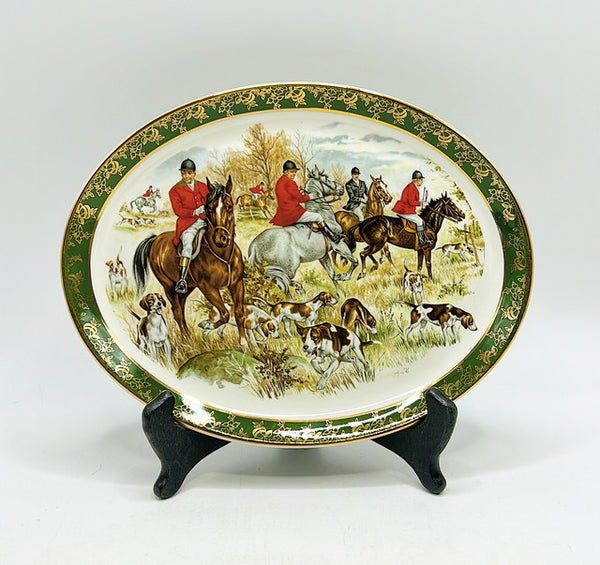 Vintage 80s oval decorative fox hunt scene with hunters in horses with hunting dogs scene.