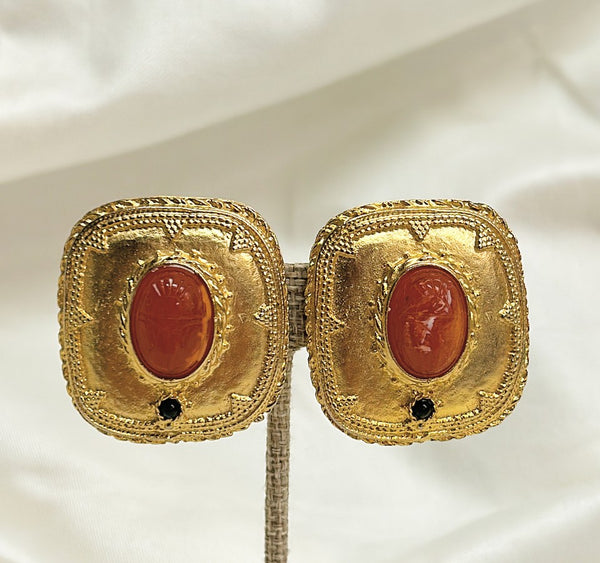 Fabulous statement size 1980s clip on designer style earrings with orange / coral scarab etched center stone.