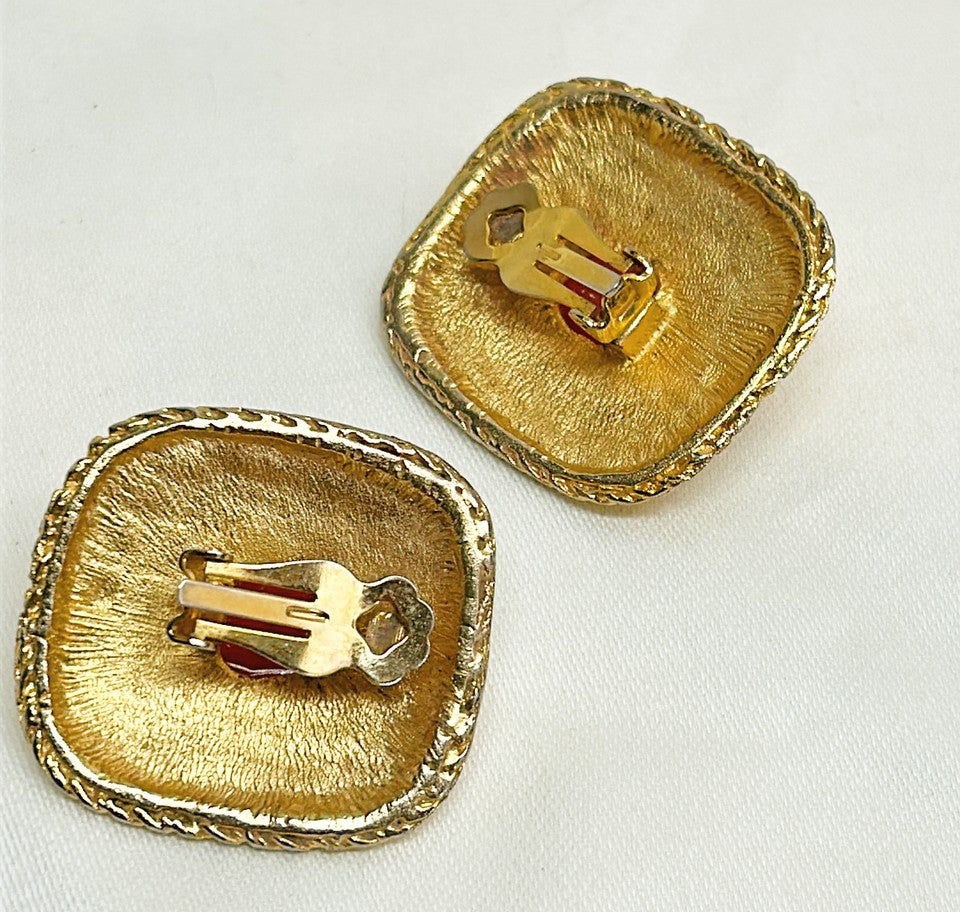 Fabulous statement size 1980s clip on designer style earrings with orange / coral scarab etched center stone.