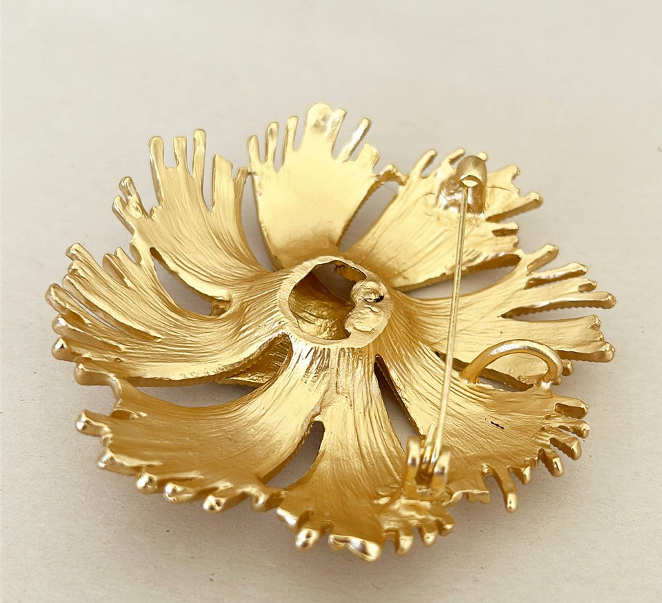 Vintage mid-century style brooch in a gold tone metal finish.