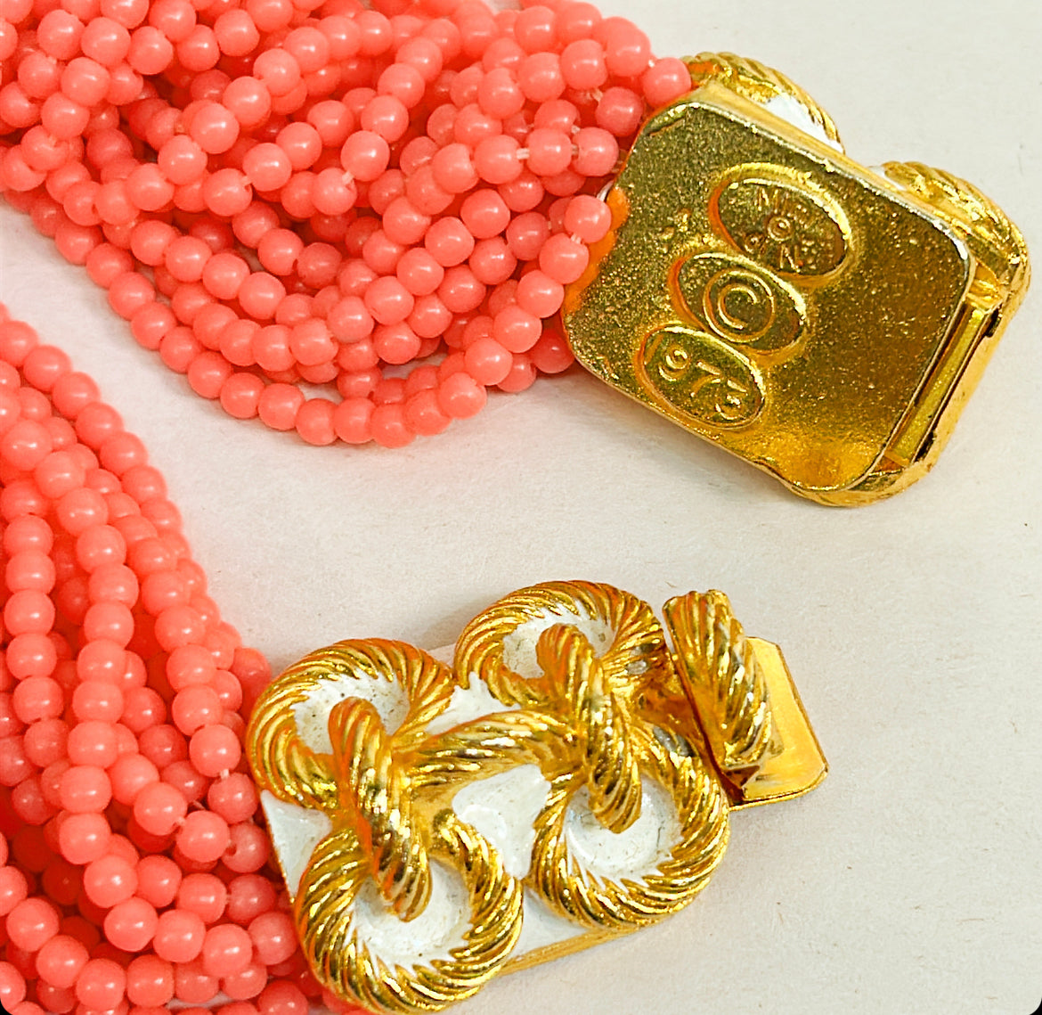 1973 Mimi Di N hot pink, multi strand, beaded collar style necklace with gold class bow stamped with a rope design. Approximately 17 inches long with fully open by 1 inch thick.