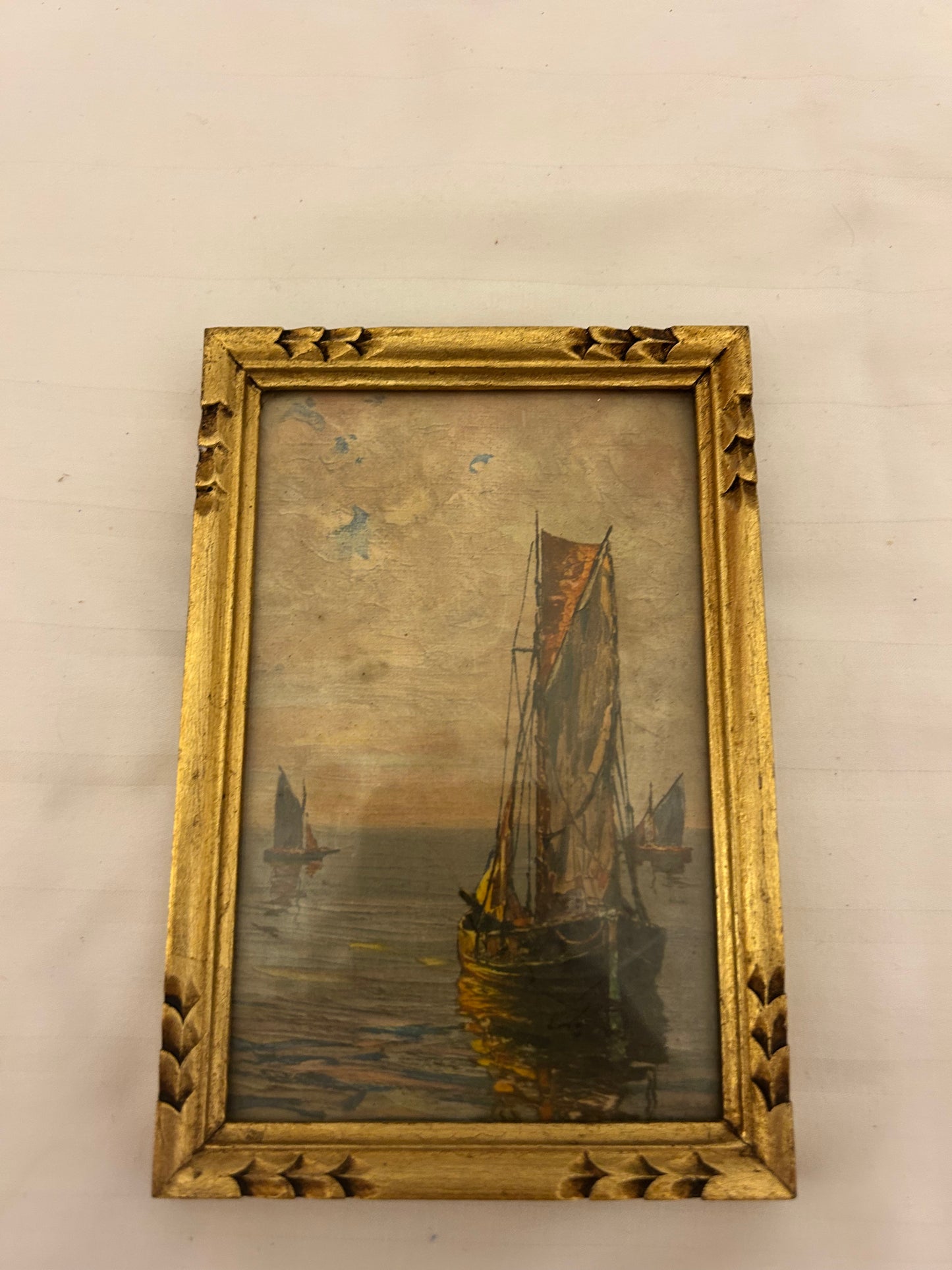 This vintage oil painting on canvas depicts a serene maritime scene