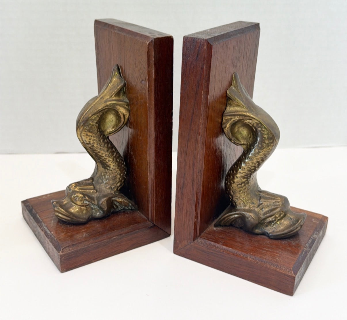 Vintage pair of wooden and brass dolphin book ends.
