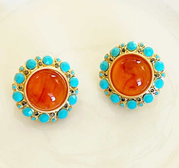 Round pierced earrings with large center orange cabochon style stone