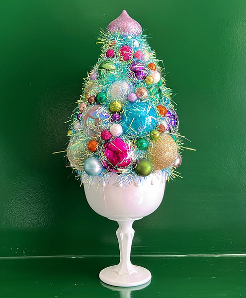 Handmade Christmas tree topiary in a vintage white milk glass urn.