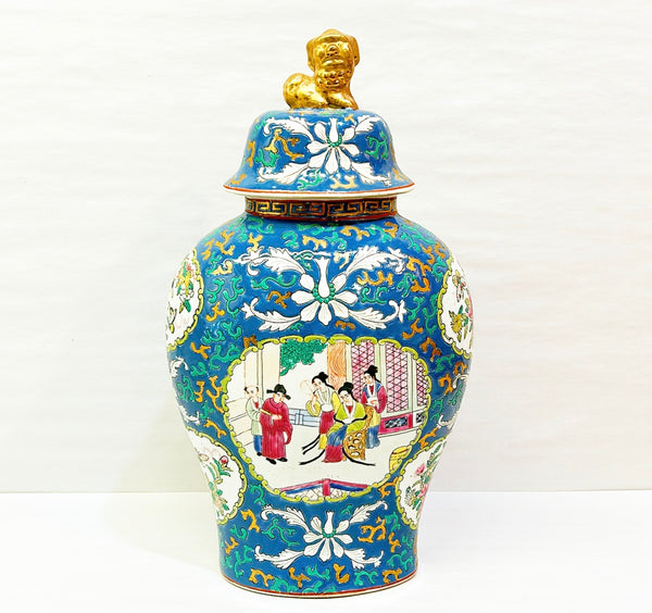 Vintage porcelain export vase with foo dog lid. Famille Rose style design with a blue background.