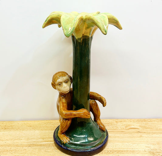 Decorative chinoiserie style monkey hugging palm tree candlestick.