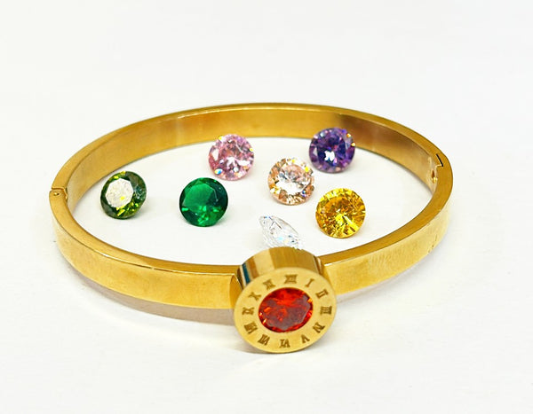 Vintage hinged bracelet with front round clock style face with interchangeable colorful faux gemstones.