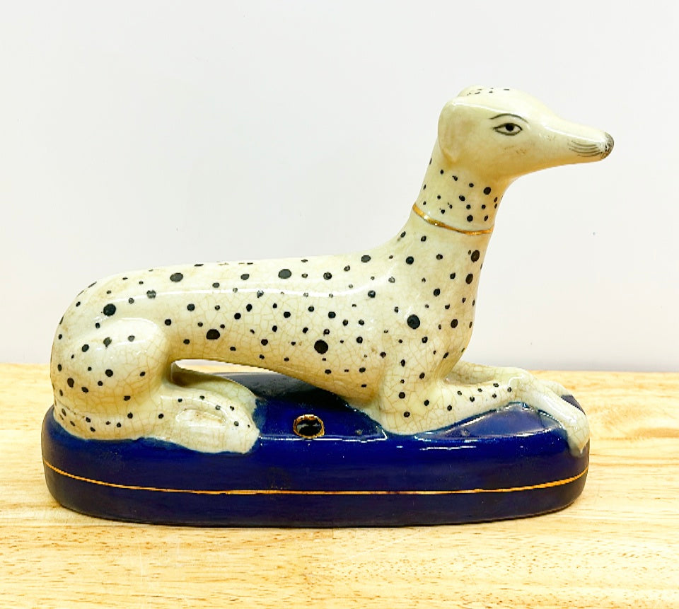 Classic vintage Staffordshire style dog laying on oval blue base