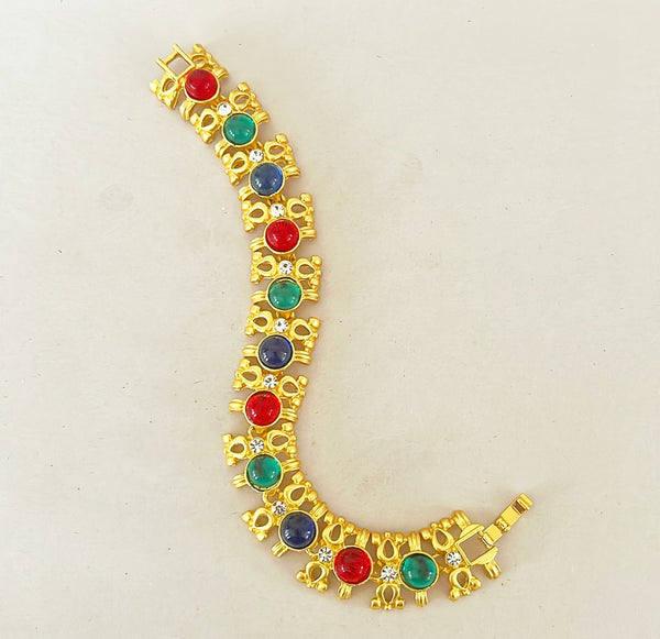 Classic vintage couture style multi colored gripoix link bracelet in a gold tone metal finish and rhinestone accents.