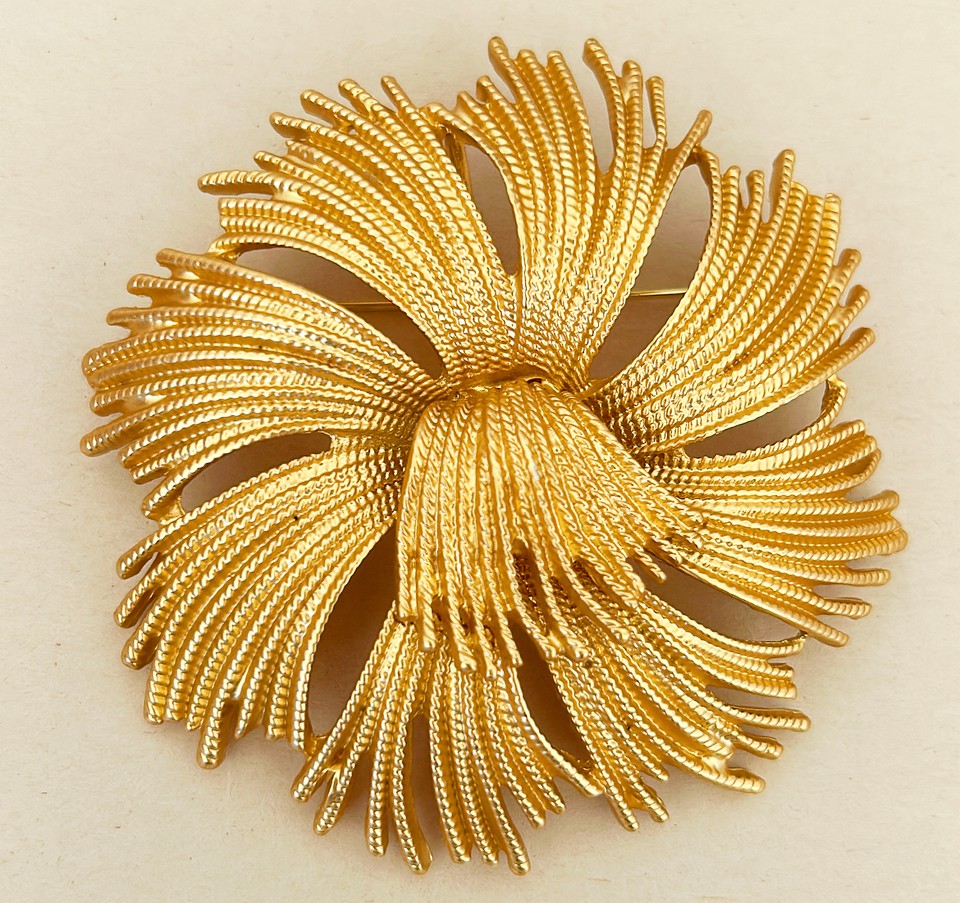 Vintage mid-century style brooch in a gold tone metal finish.