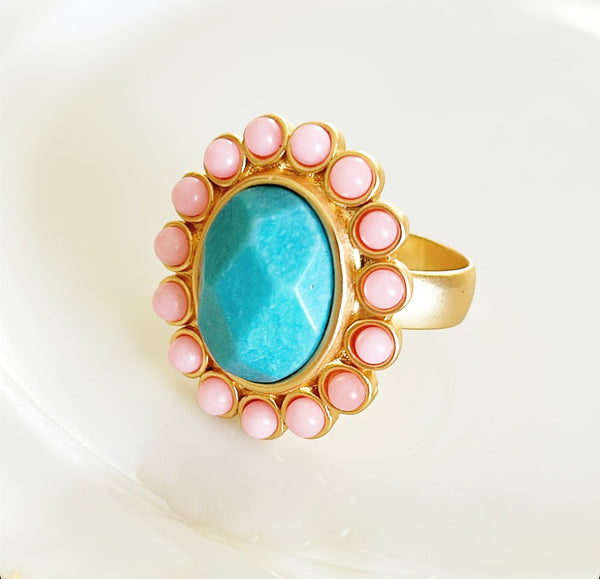 Larger style cocktail ring with oval faux turquoise stone with pink round cabochon style stones.