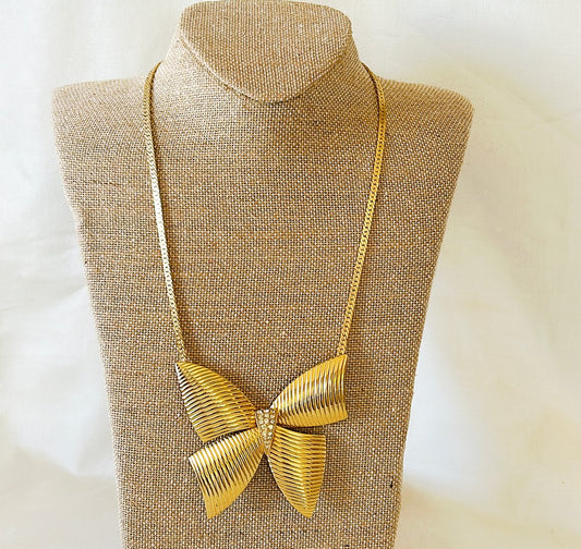 Adorable 80s gold necklace with extra large bow with rhinestone accents.