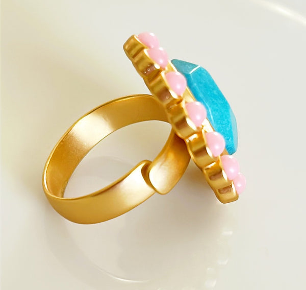 Larger style cocktail ring with oval faux turquoise stone with pink round cabochon style stones.