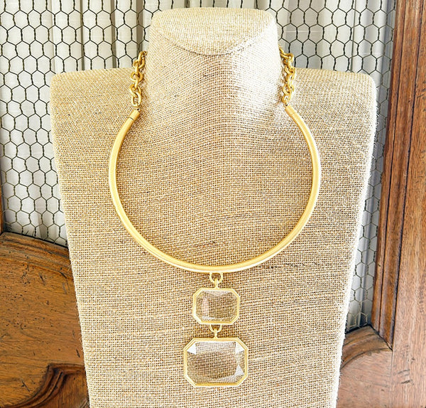 Simple gold metal collar style necklace with attached clear crystal style double pendant.
