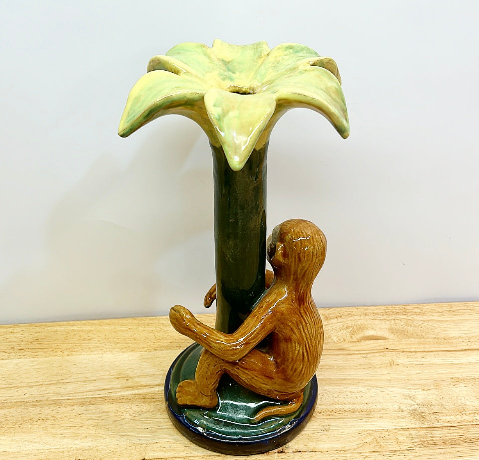 Decorative chinoiserie style monkey hugging palm tree candlestick.