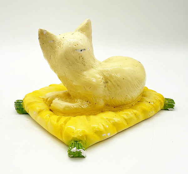 Mid century 1960s Italian style kitty laying in a yellow pillow with green tassels.