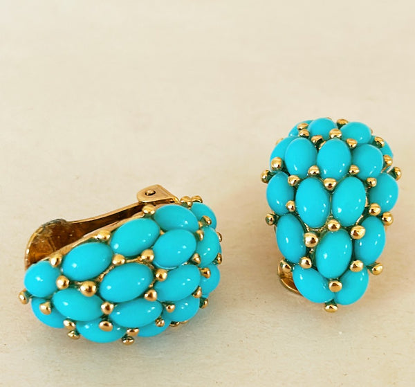 Vintage signed KJL clip on faux turquoise earrings set in a gold metal tone finish.