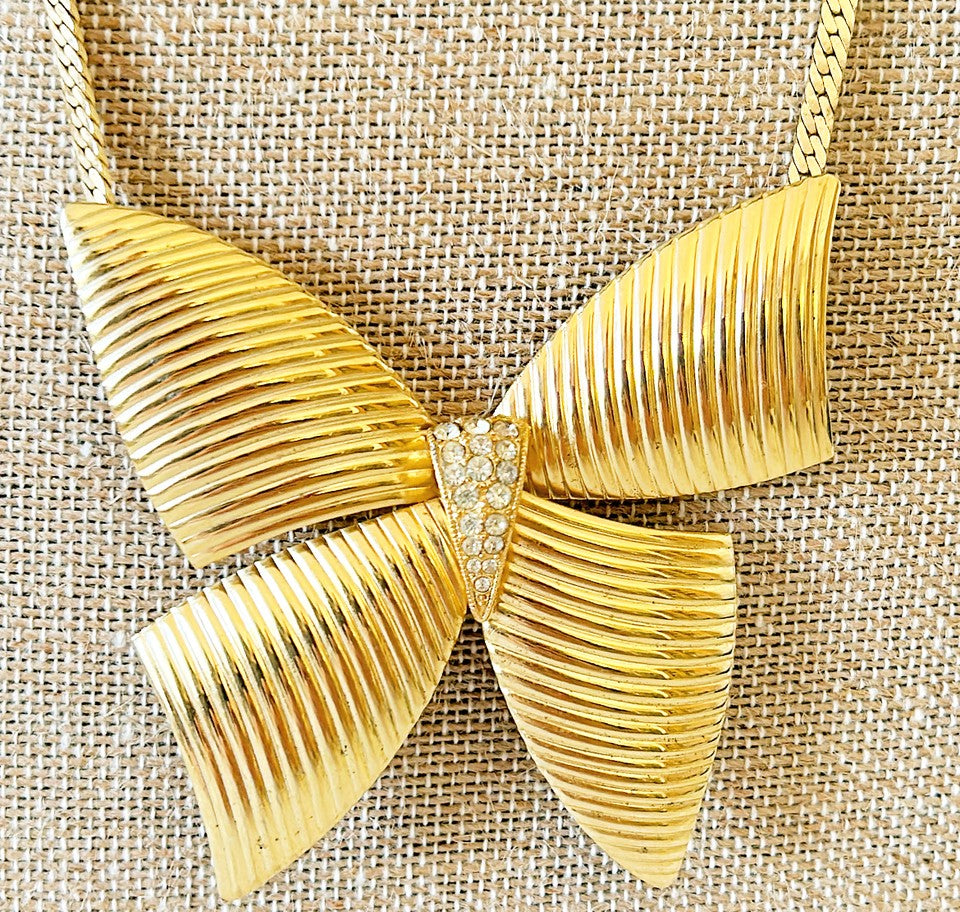 Adorable 80s gold necklace with extra large bow with rhinestone accents.