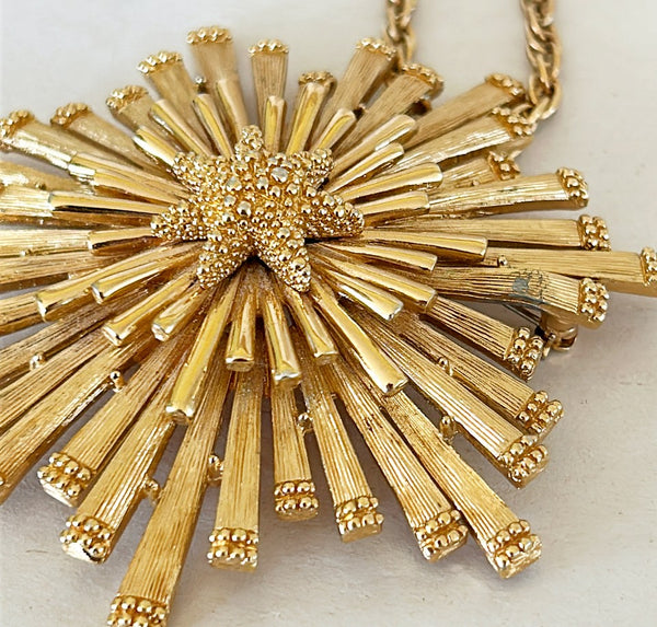 1960s vintage signed Monet starburst style dual pedant / brooch set in a gold tone metal finish and a gold tone metal finish chain