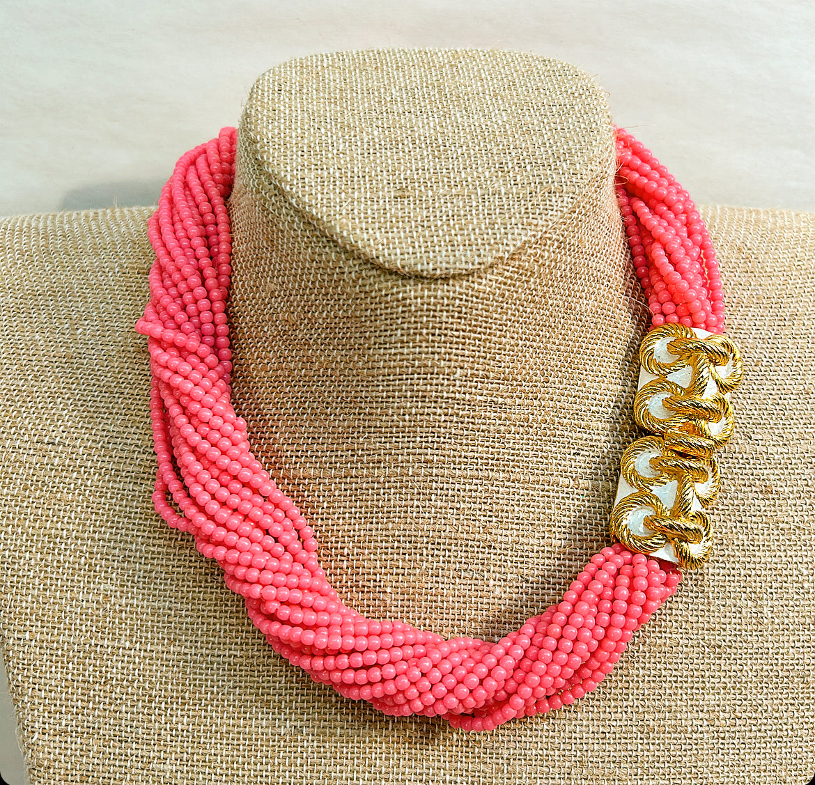 1973 Mimi Di N hot pink, multi strand, beaded collar style necklace with gold class bow stamped with a rope design. Approximately 17 inches long with fully open by 1 inch thick.