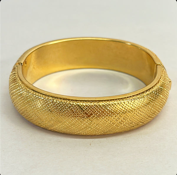 Vintage 1980s Monet signed hinged gold metal bracelet with clasp.
