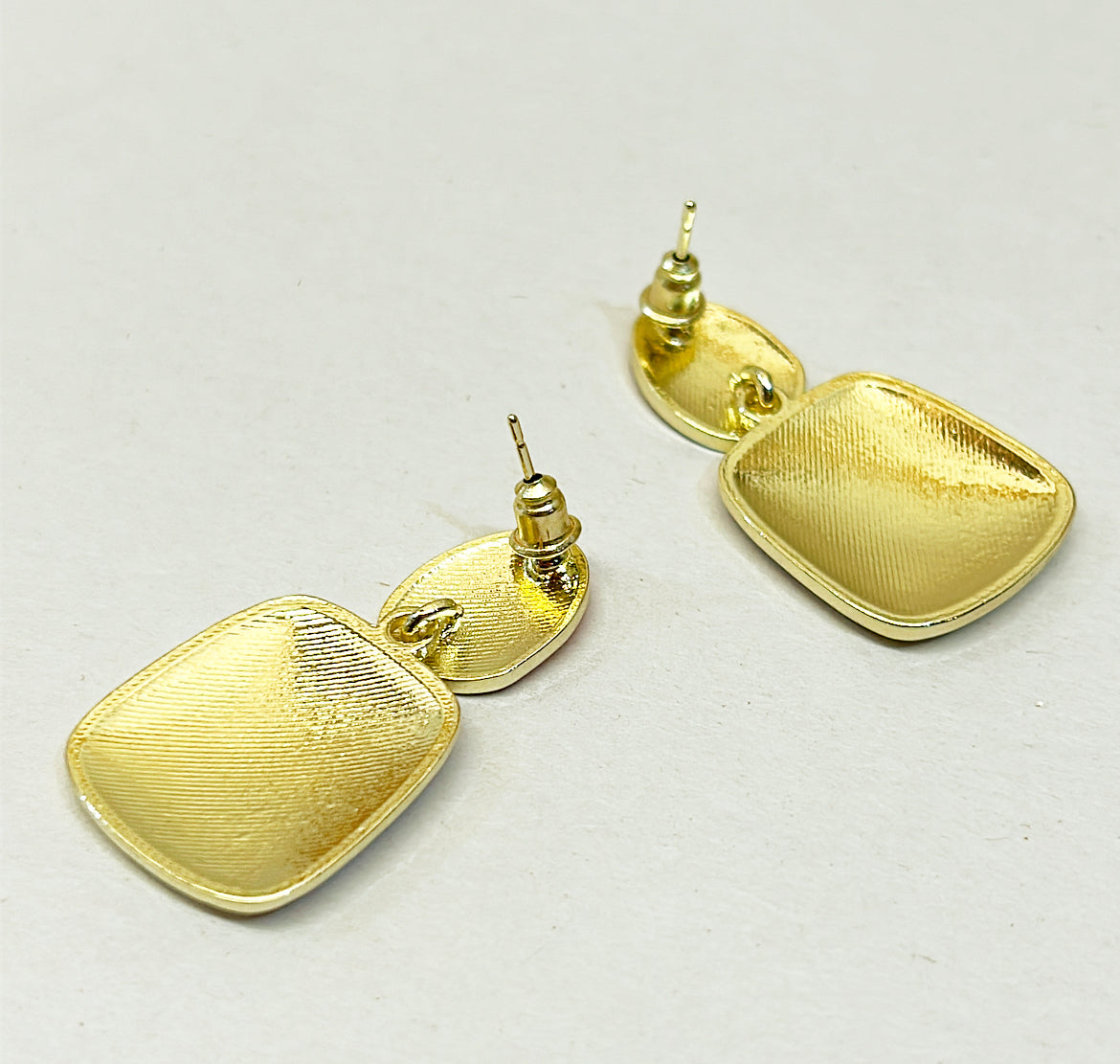 Fun cloth block style pierced earrings set in a gold metal frame settings with orange &amp; white enamel accents