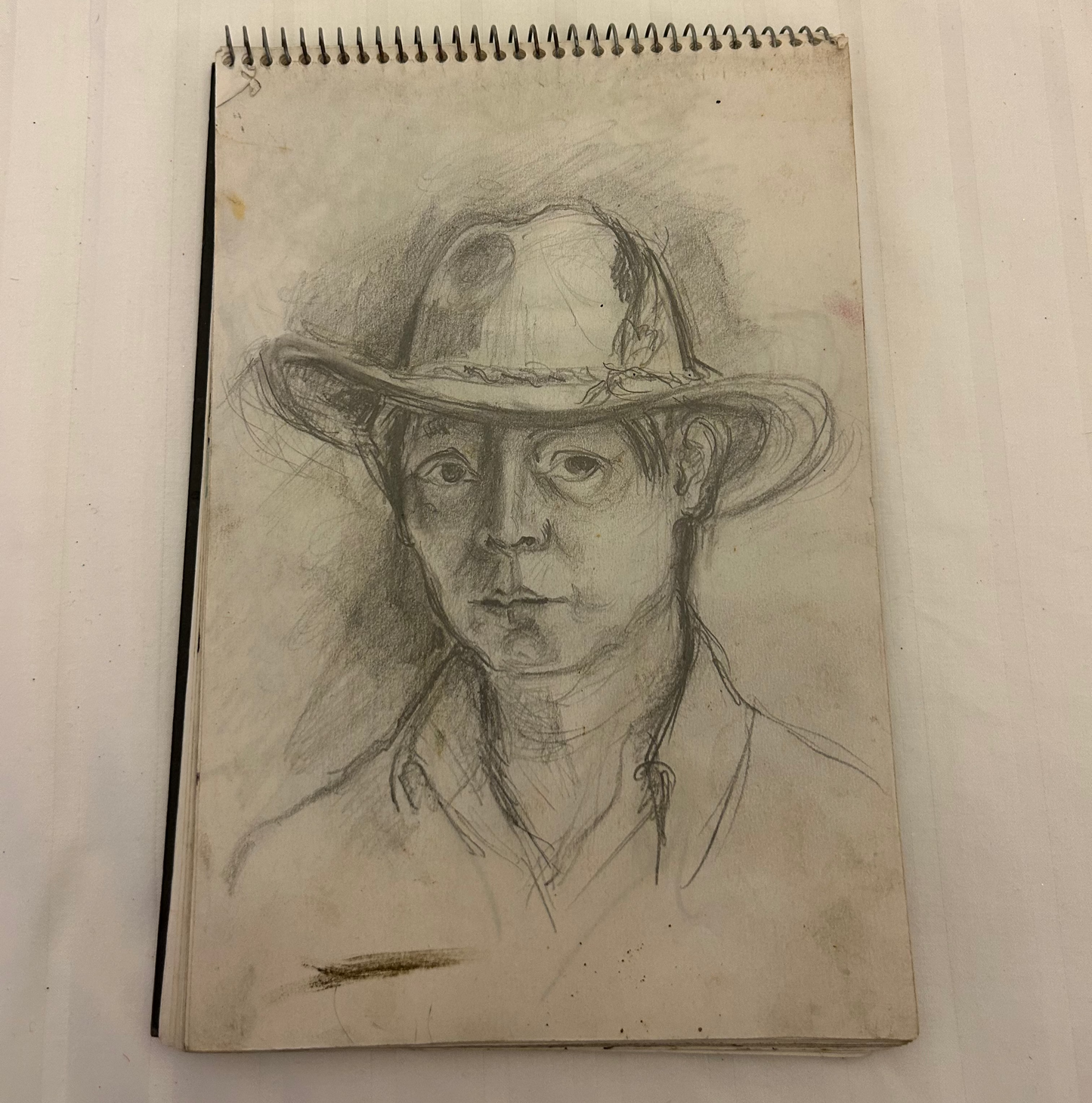 This image is a charcoal or pencil sketch of a person wearing a cowboy hat,