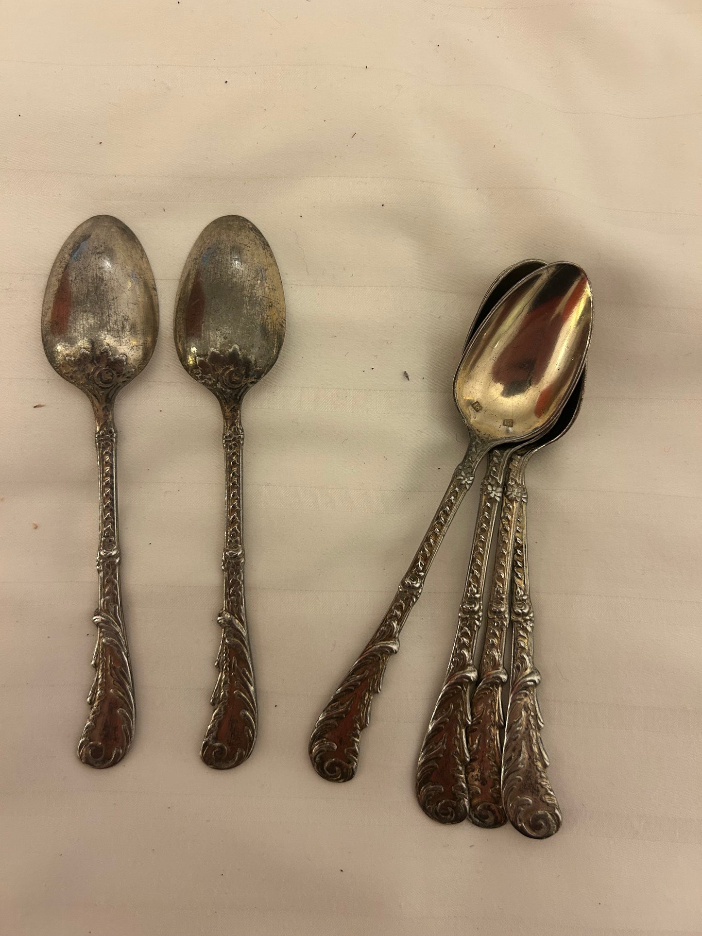 vintage silver flatware spoons featuring a highly ornate, Baroque-style scroll pattern on the handle